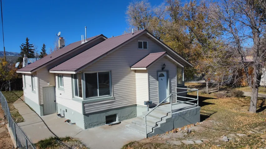 View of front of house featuring a metal roof and a chimney
