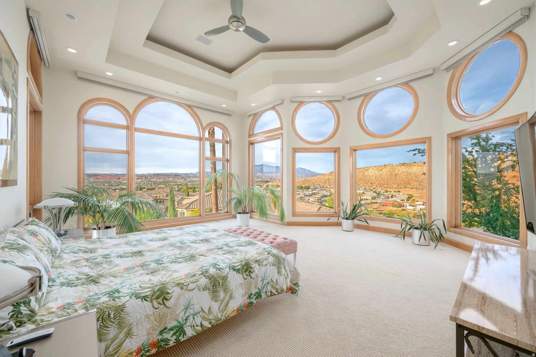 Carpeted bedroom with a raised ceiling, a towering ceiling, and recessed lighting