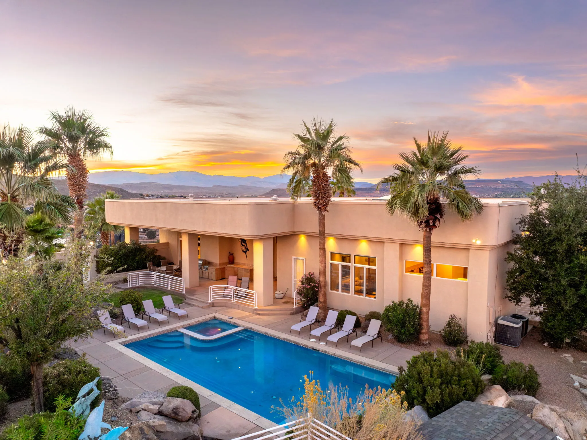Rear view of property with a patio area, a mountain view, stucco siding, and a pool with connected hot tub