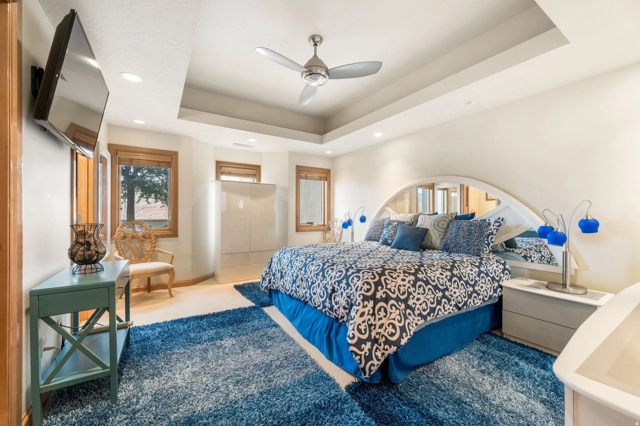 Bedroom featuring a ceiling fan, a tray ceiling, carpet flooring, and recessed lighting