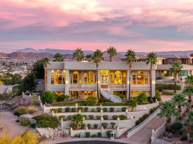 Back of property at dusk with stairway, stucco siding, and a mountain view