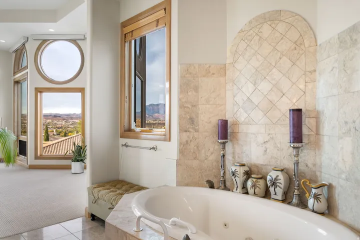 Bathroom with a tub with jets, tile walls, carpet, and tile patterned floors