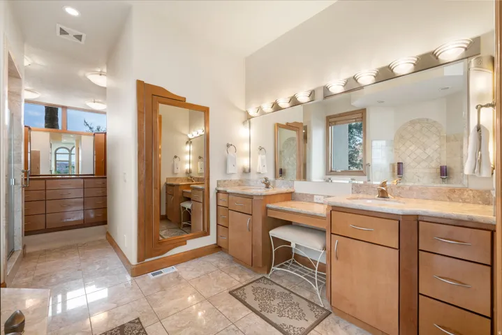 Bathroom with two vanities, a stall shower, light tile patterned floors, and recessed lighting