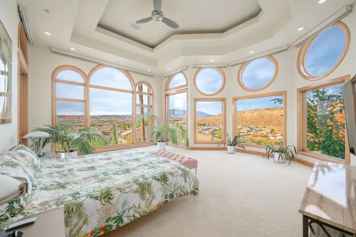 Carpeted bedroom with a raised ceiling, a towering ceiling, and recessed lighting