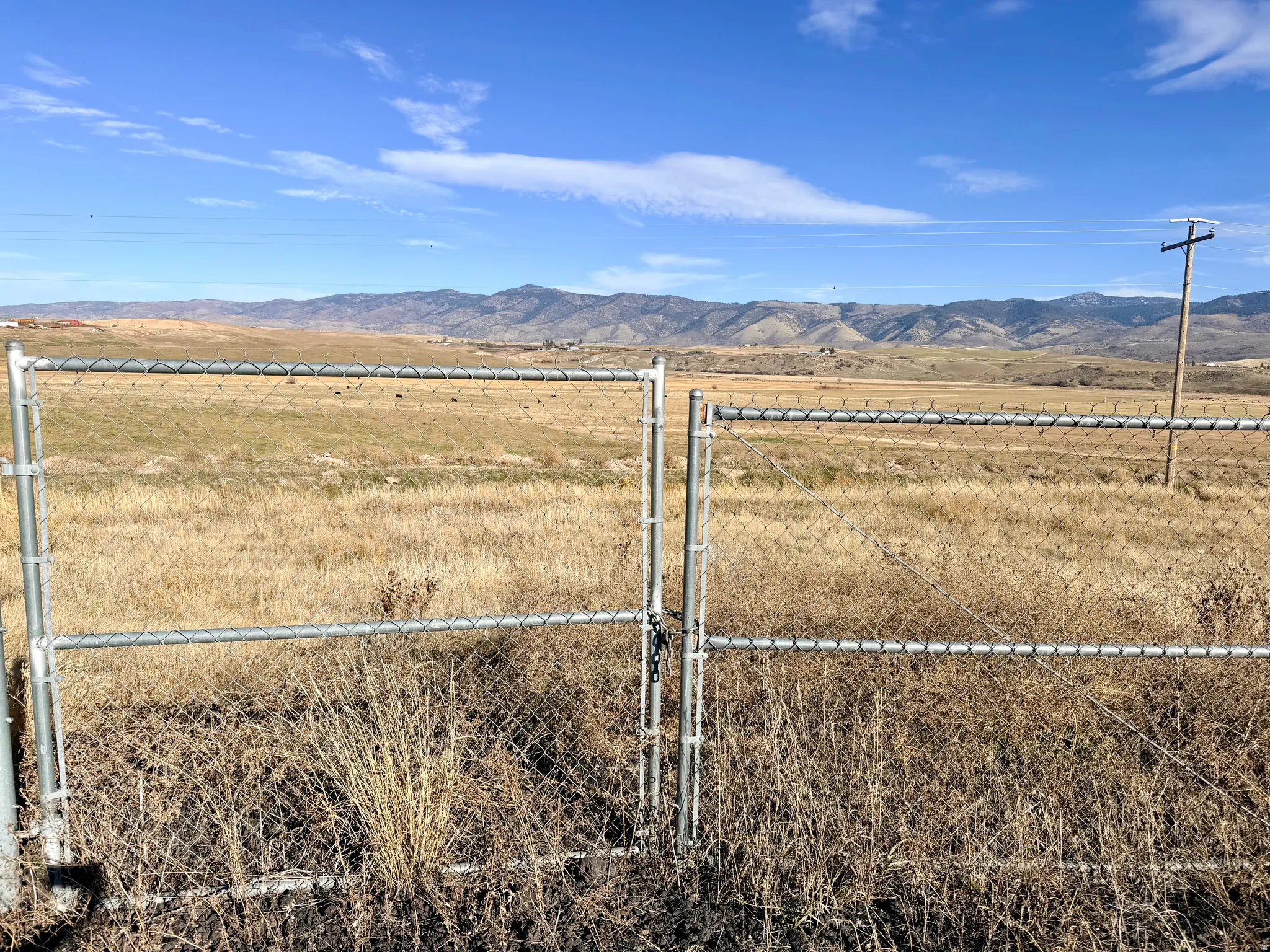 View of yard featuring a mountain view, a gate, and a view of countryside