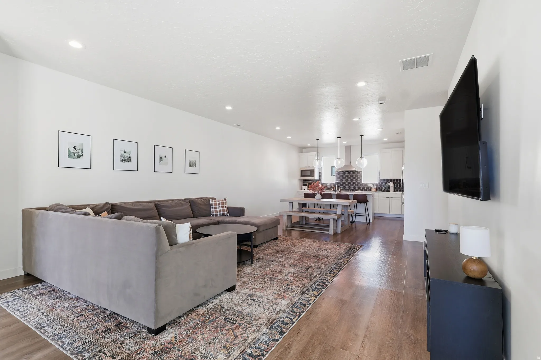 Living room featuring dark wood-style flooring and recessed lighting