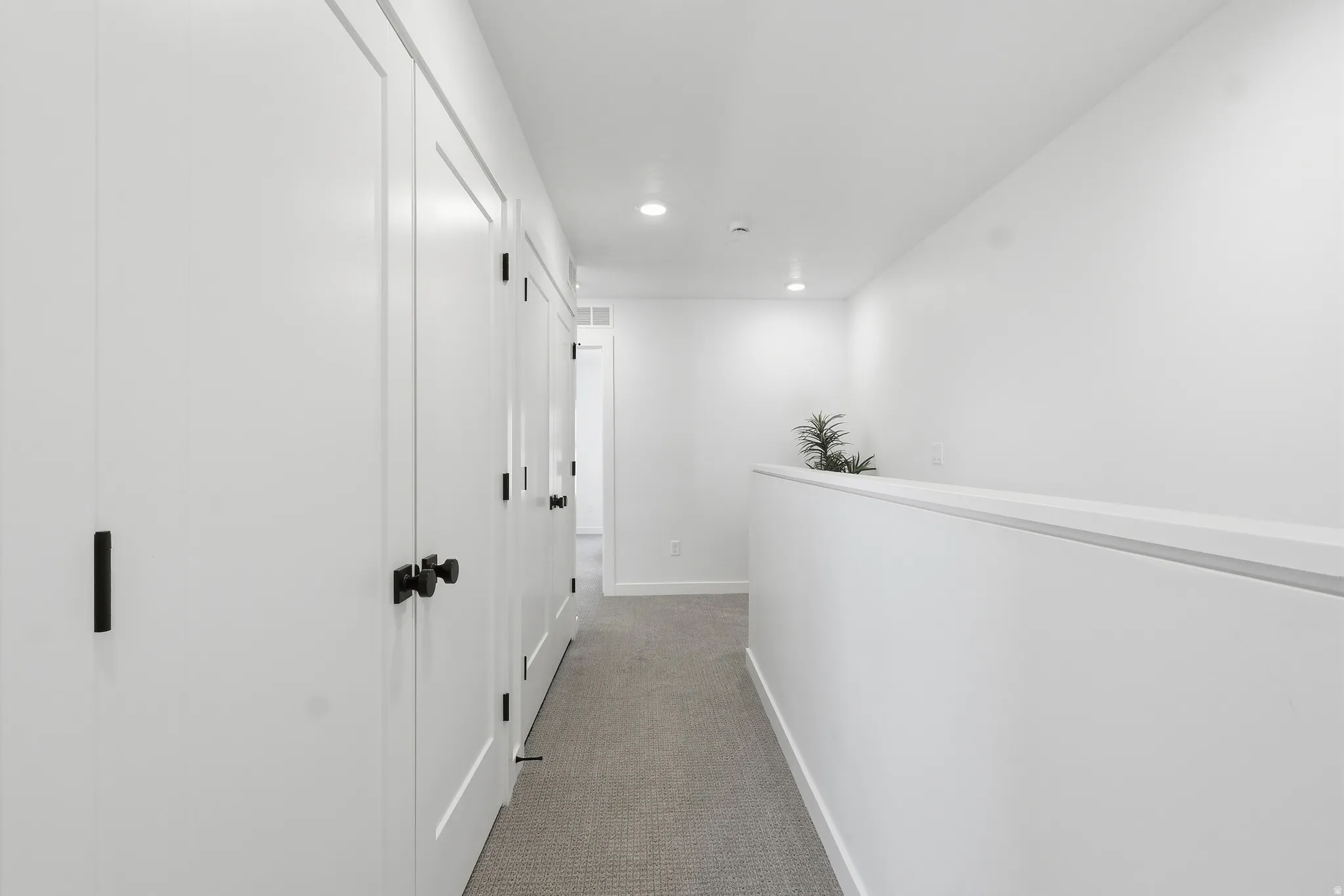 Hall with light carpet and recessed lighting
