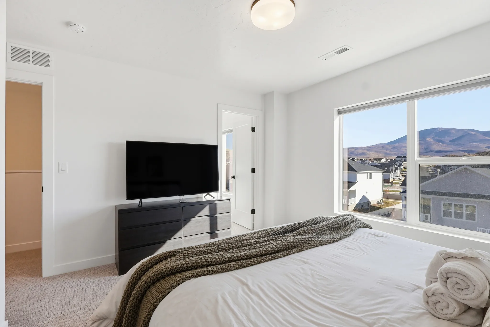 Bedroom featuring light carpet and baseboards