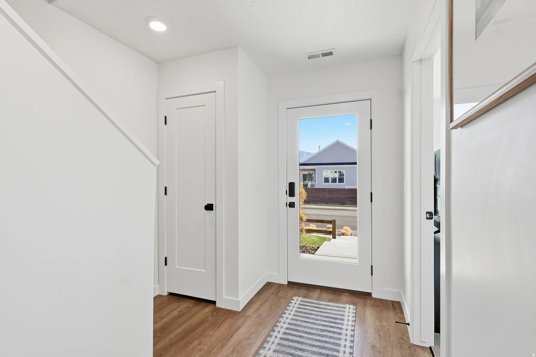 Foyer with light wood finished floors and recessed lighting