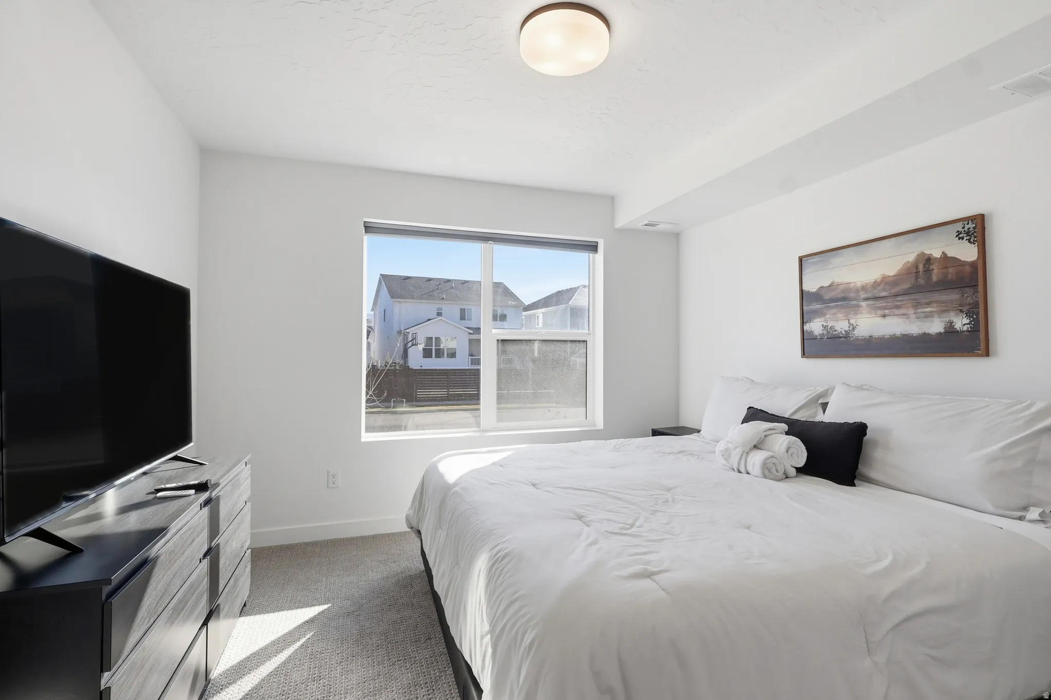 Bedroom featuring light carpet and baseboards