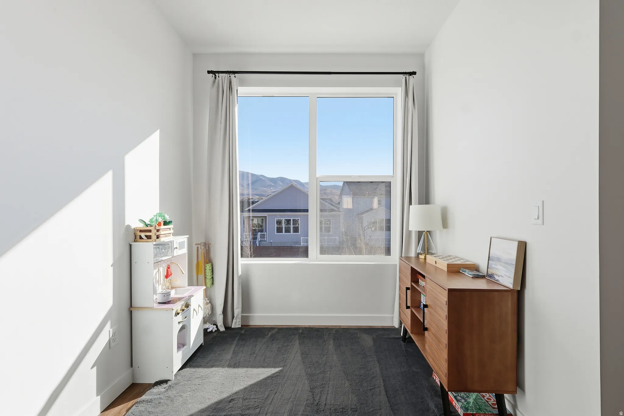 Sitting room featuring dark colored carpet and a mountain view