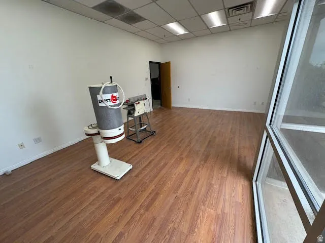 Spare room with wood finished floors and a drop ceiling