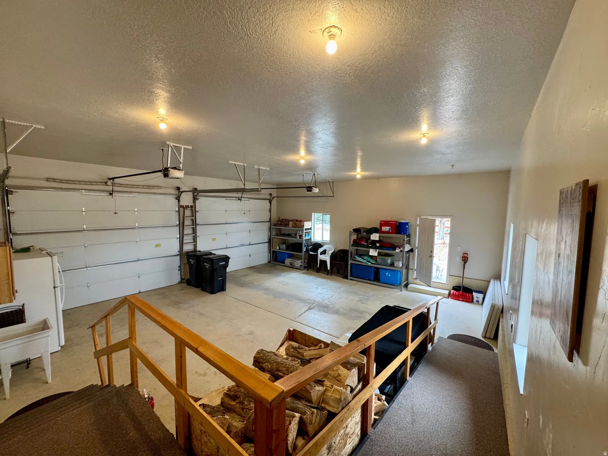 Garage with freestanding refrigerator and a garage door opener