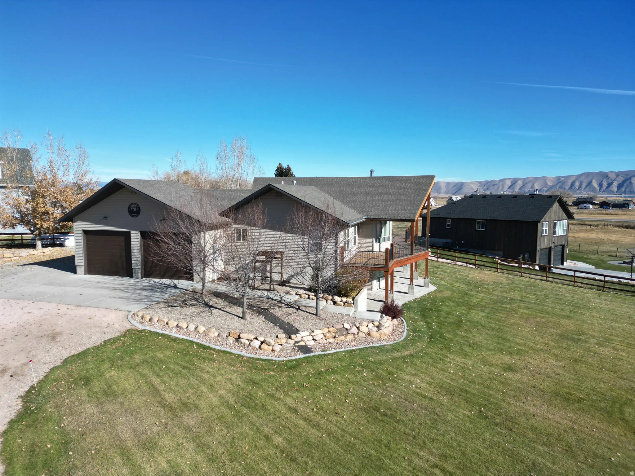 View of front of property with concrete driveway, a garage, a mountain view, and roof with shingles