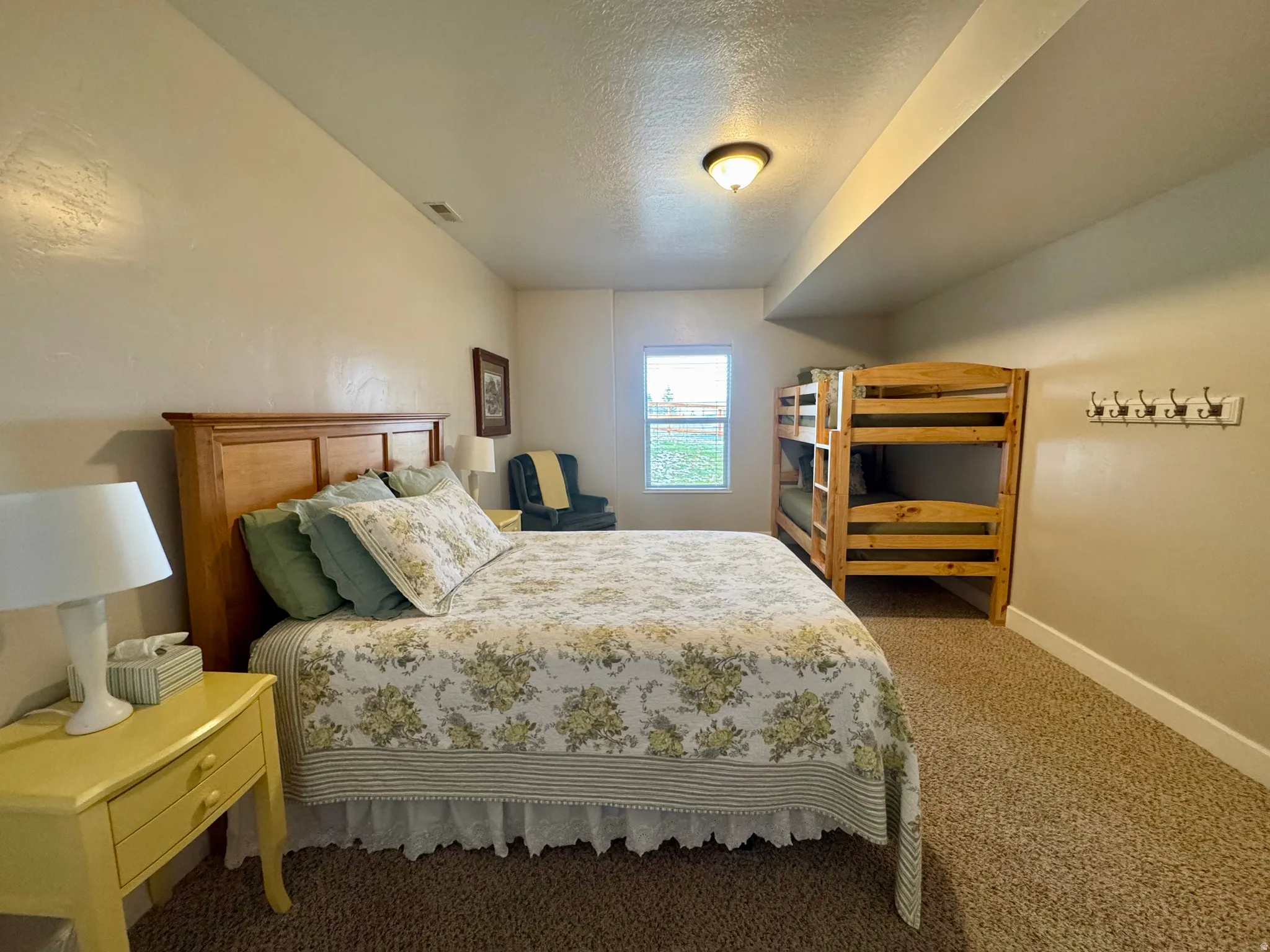 Carpeted bedroom with a textured ceiling and baseboards