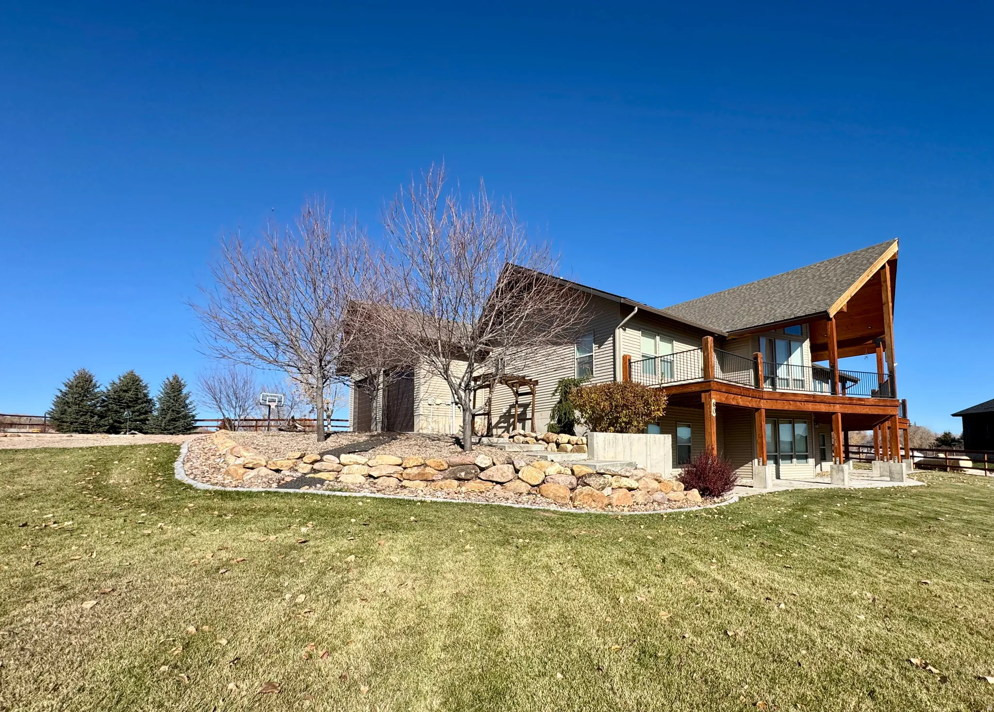 Rear view of property featuring a patio, a lawn, and a wooden deck