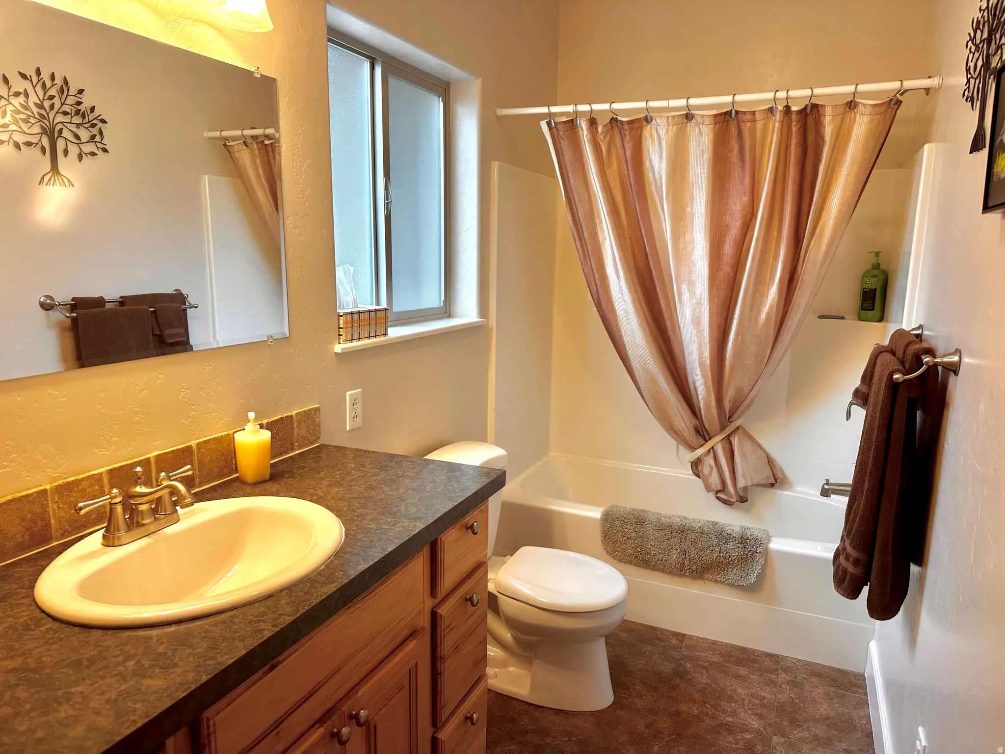 Full bath with shower / tub combo with curtain, vanity, and a textured wall