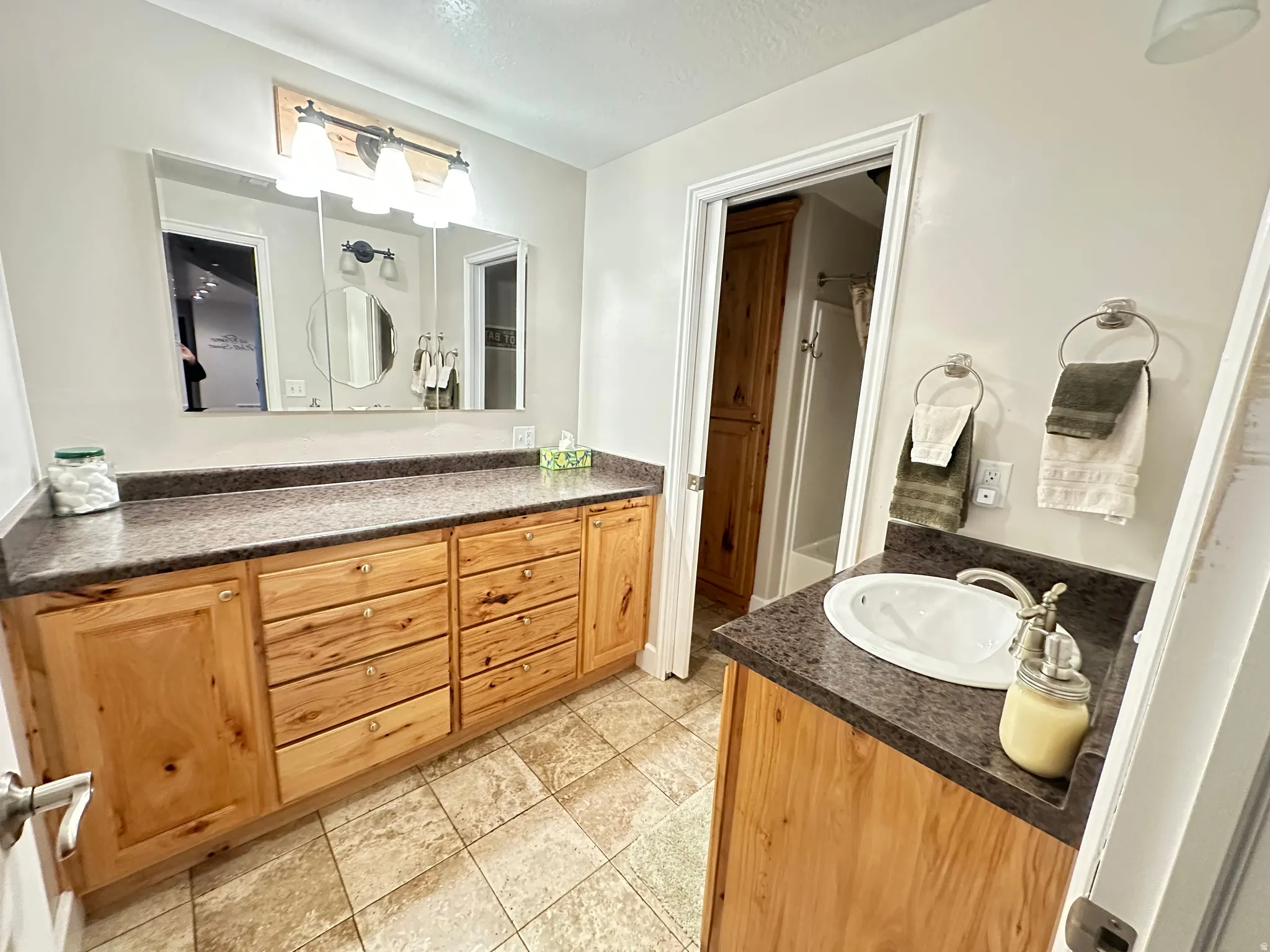 Full bathroom with vanity and light tile patterned floors