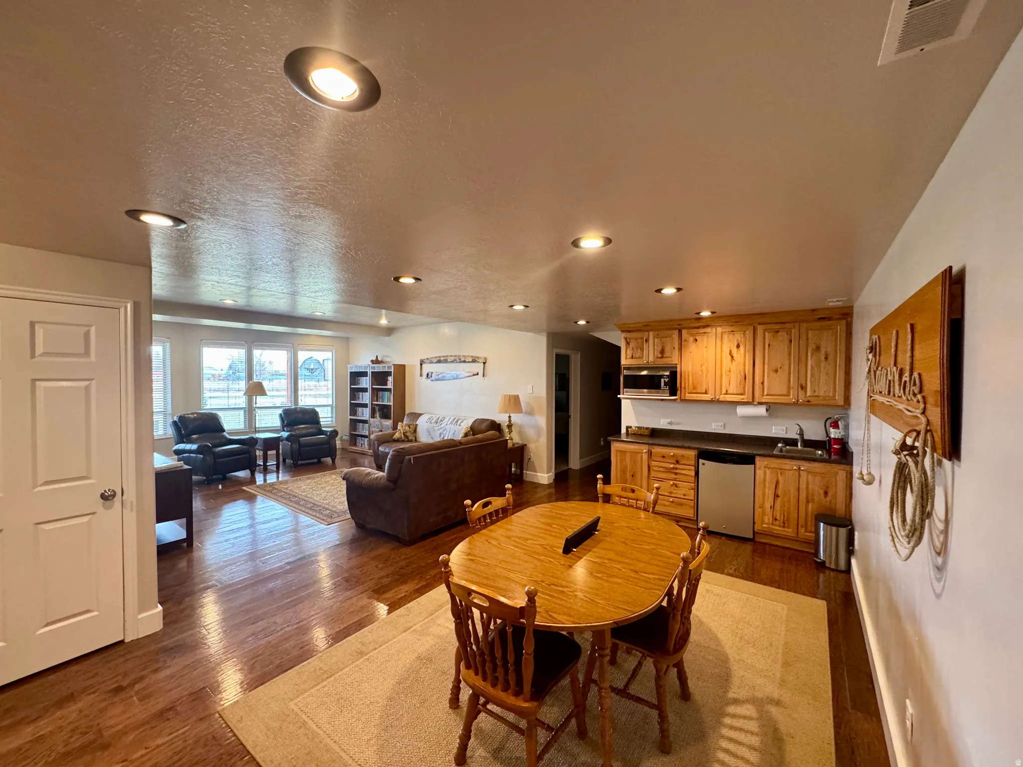 Dining room with dark wood-type flooring, recessed lighting, and a textured ceiling
