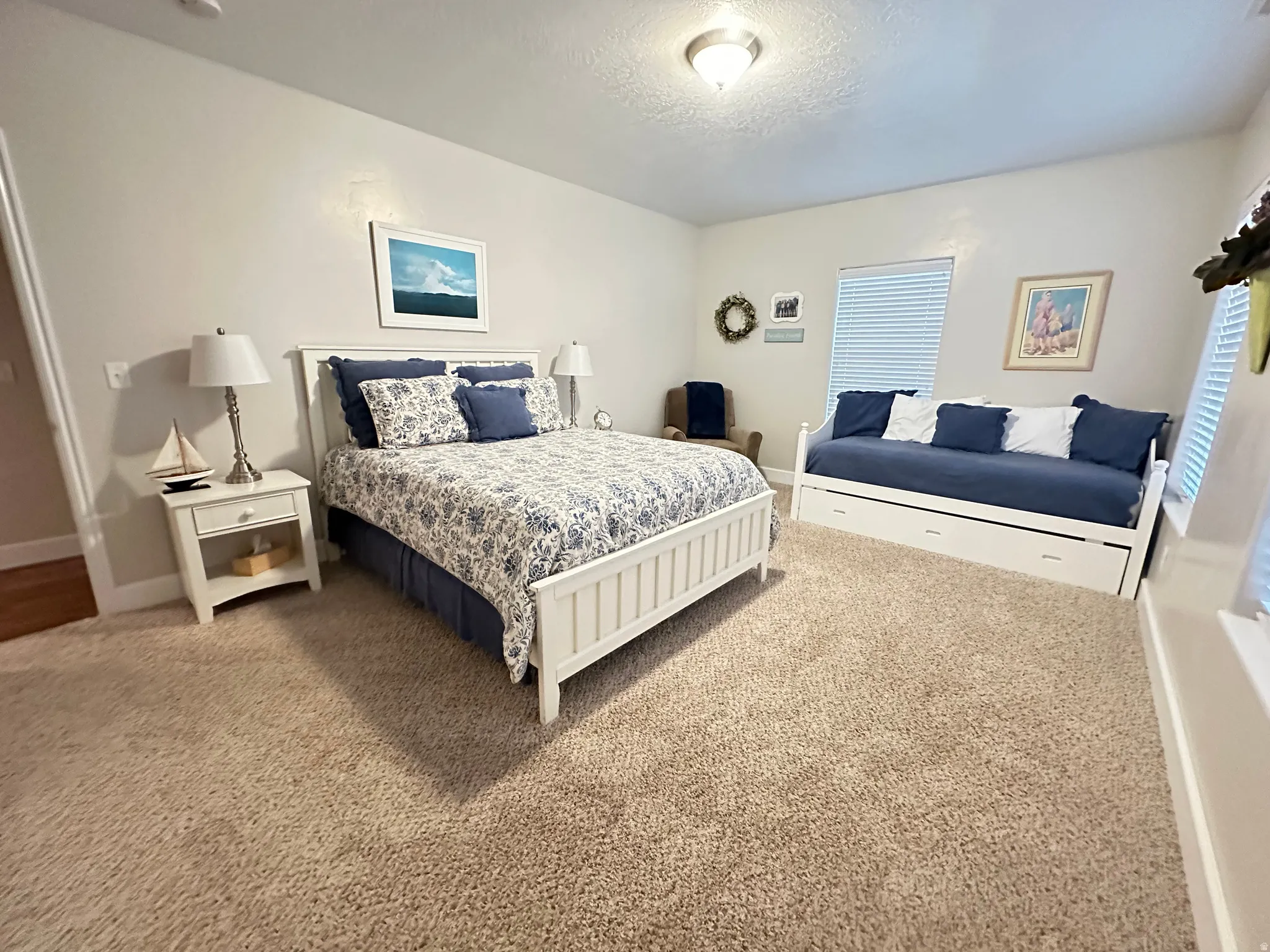 Carpeted bedroom featuring a textured ceiling and baseboards