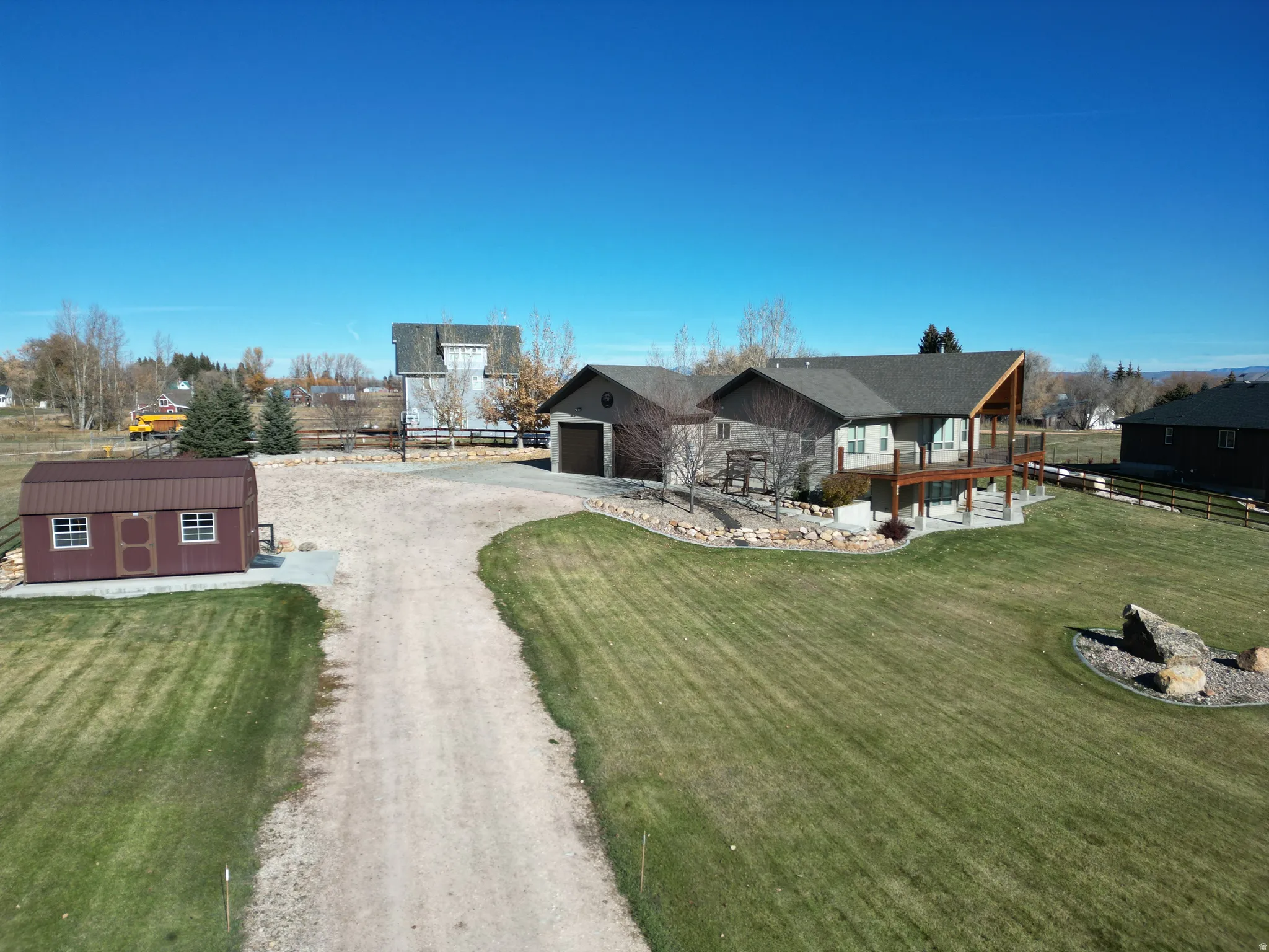 View of front of property with driveway and a shed