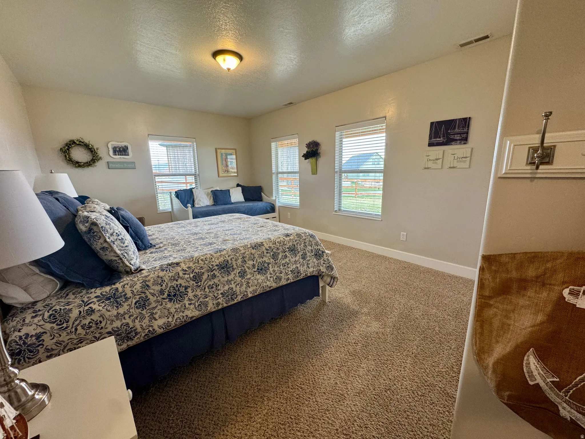 Carpeted bedroom featuring baseboards and a textured ceiling