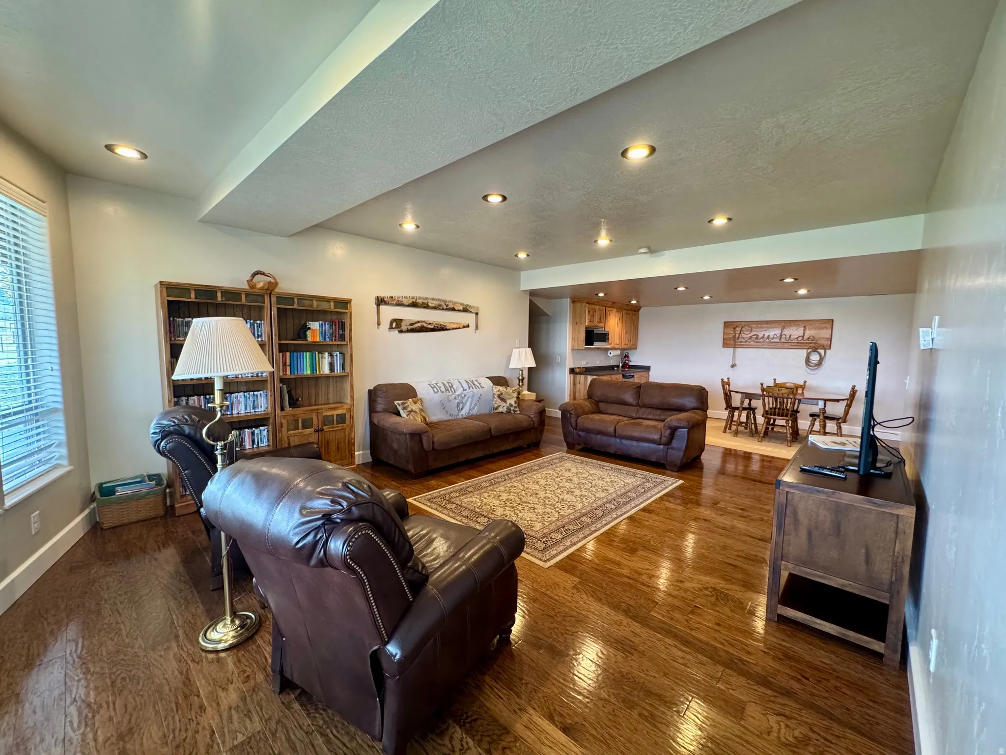 Living area with dark wood finished floors, a textured ceiling, and recessed lighting