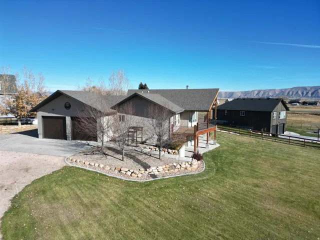 View of front of property with concrete driveway, a garage, a mountain view, and roof with shingles