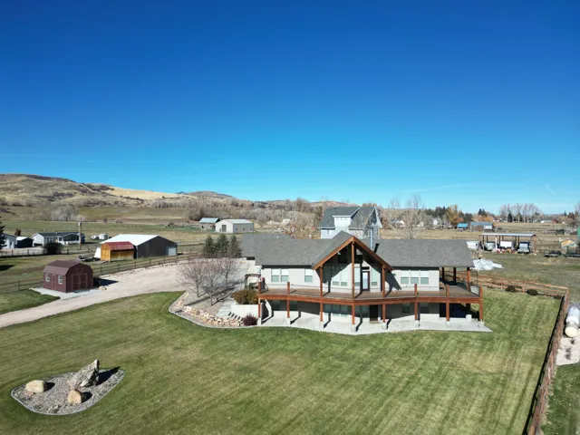 Rear view of house featuring an outdoor structure, a yard, and a patio