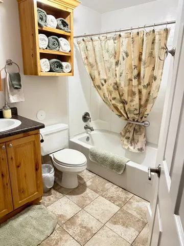 Bathroom with shower / bath combination with curtain, vanity, and light tile patterned floors