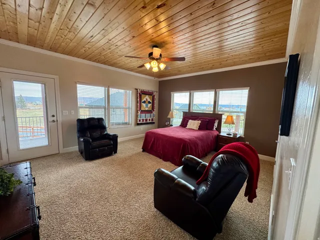 Bedroom featuring wood ceiling, ornamental molding, carpet floors, access to outside, and ceiling fan