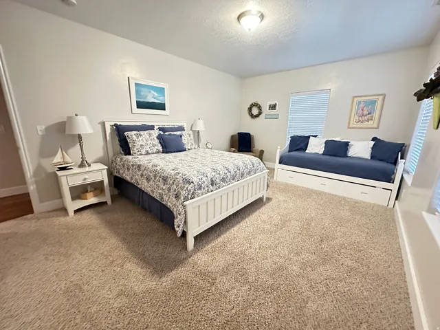 Carpeted bedroom featuring a textured ceiling and baseboards