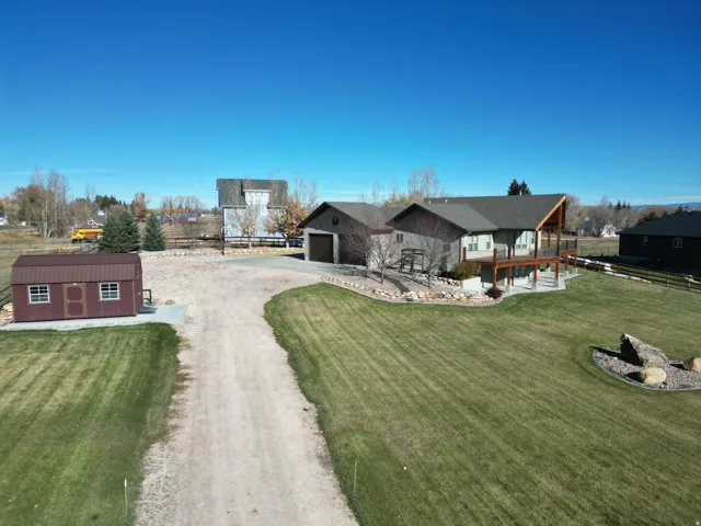 View of front of property with driveway and a shed