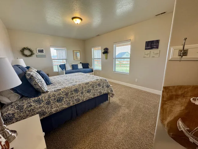 Carpeted bedroom featuring baseboards and a textured ceiling