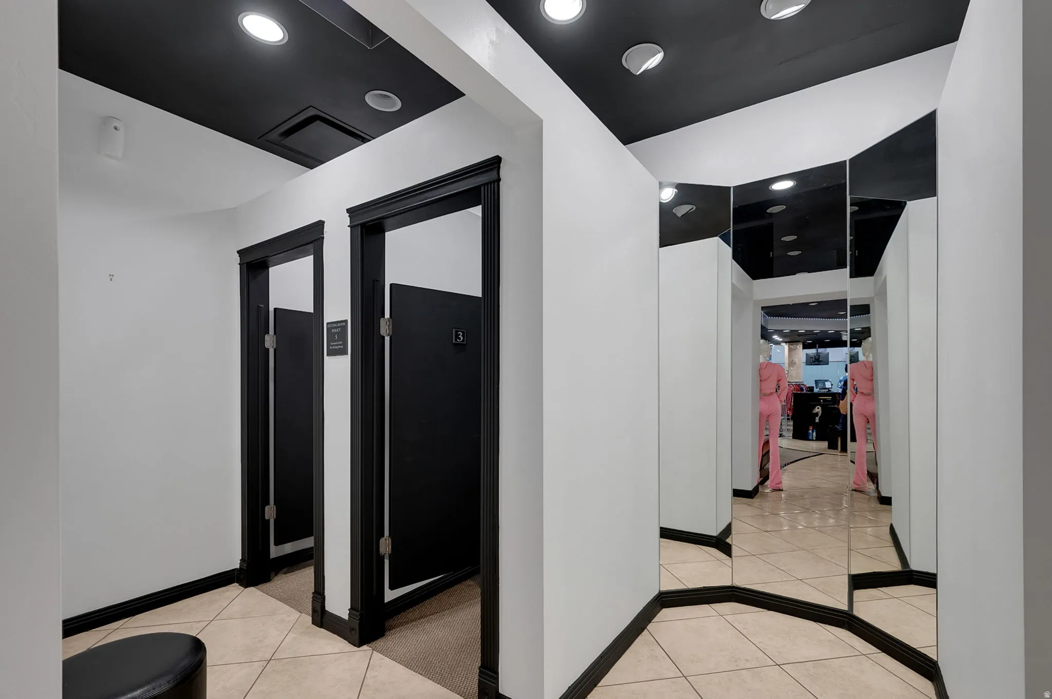 Fitting rooms featuring light tile patterned floors and recessed lighting