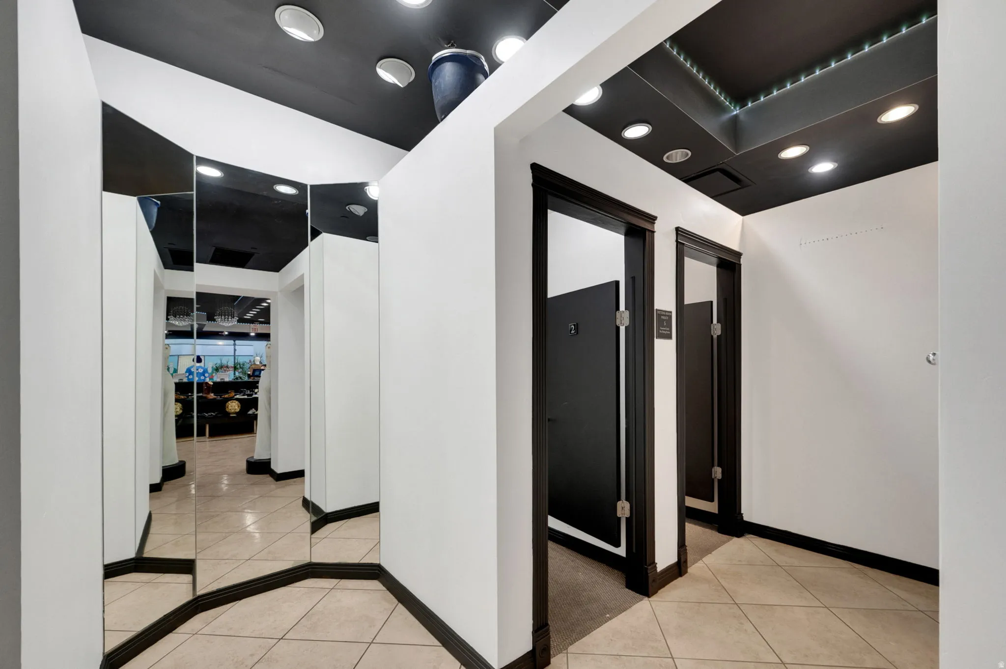 fitting rooms with  recessed lighting and light tile patterned floors