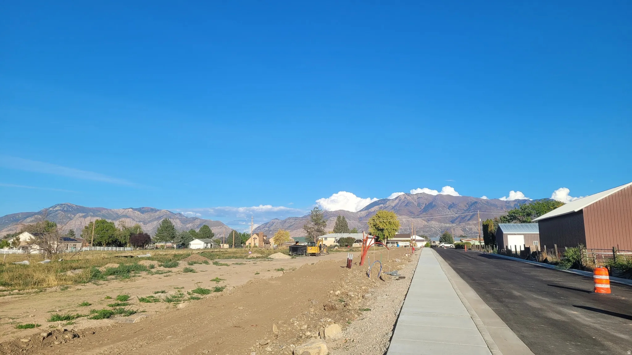 View of asphalt street featuring a mountain view and curbs