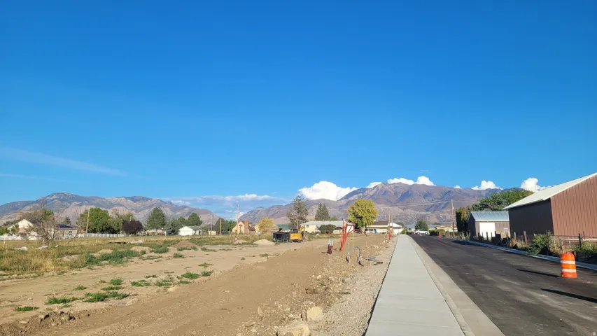 View of asphalt street featuring a mountain view and curbs