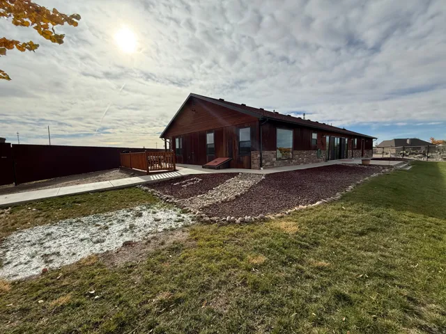 Back of property with stone siding and a patio area