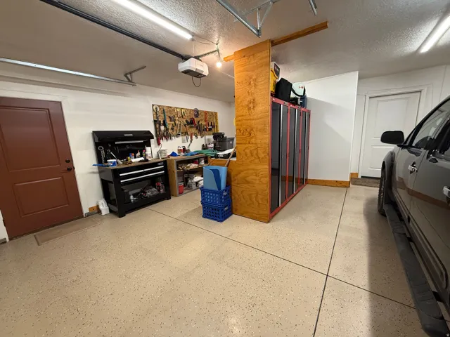 Garage featuring a workshop area and a garage door opener