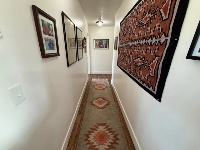 Hall with baseboards and dark wood-style floors