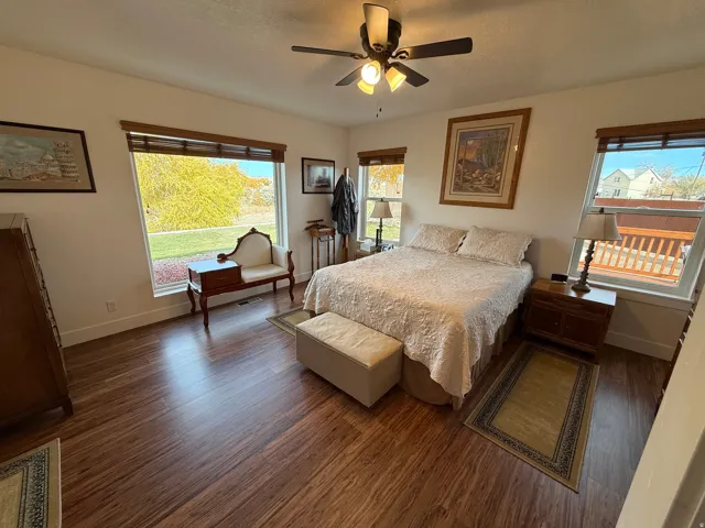 Bedroom featuring dark wood-type flooring, a ceiling fan, and a textured ceiling