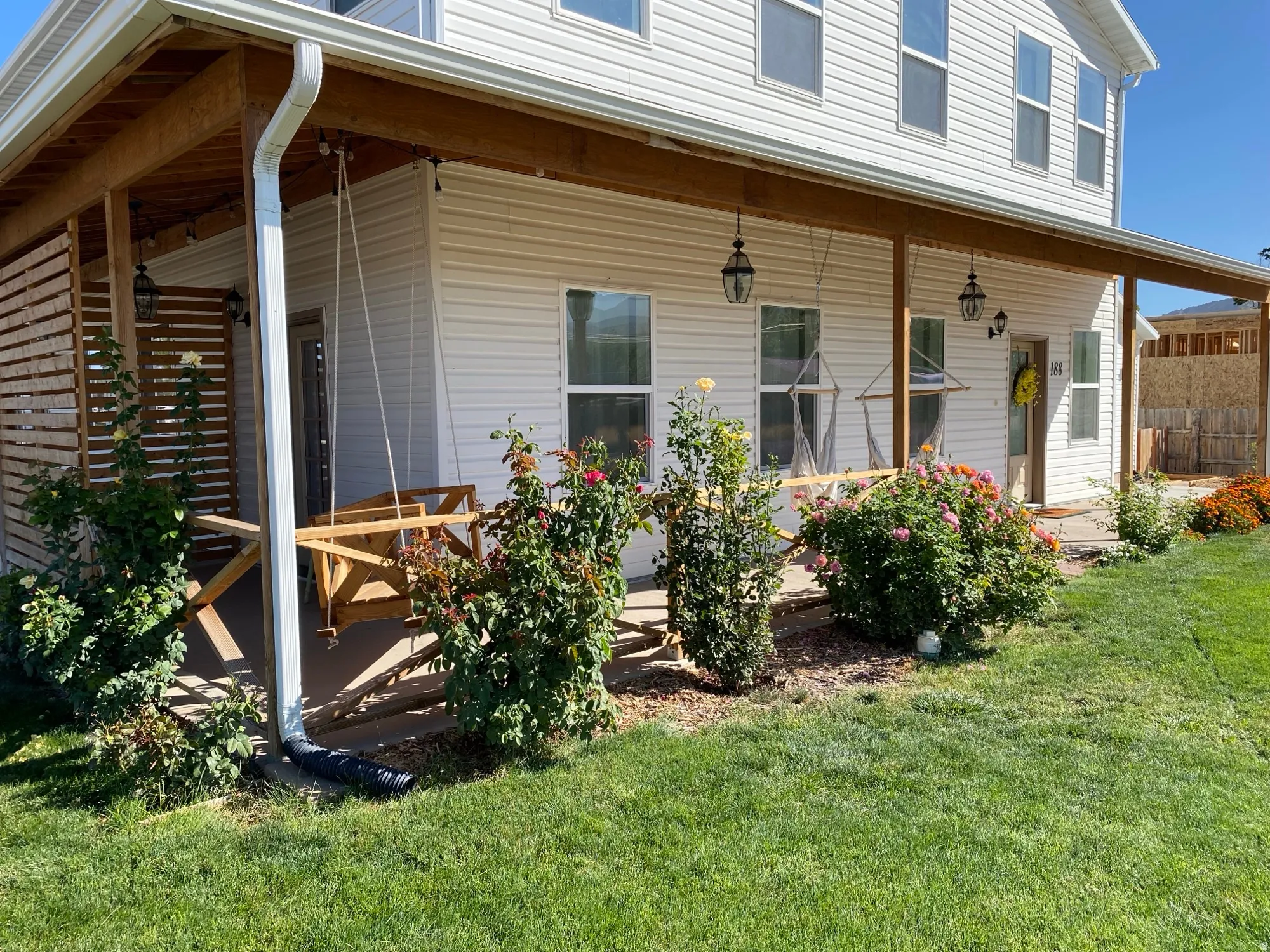 Rear view of property featuring a yard and covered porch