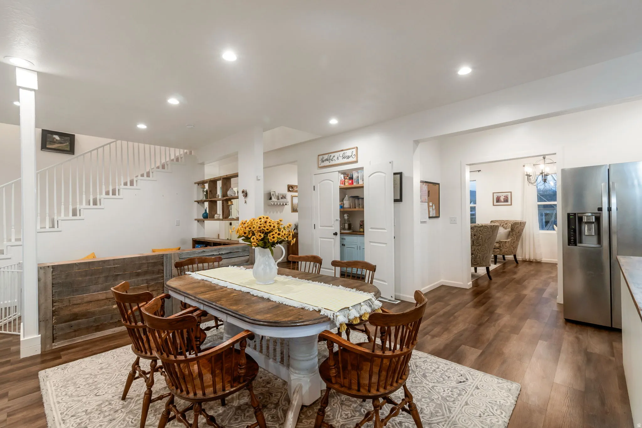 Dining room featuring dark wood-style floors, recessed lighting, stairs, and a chandelier
