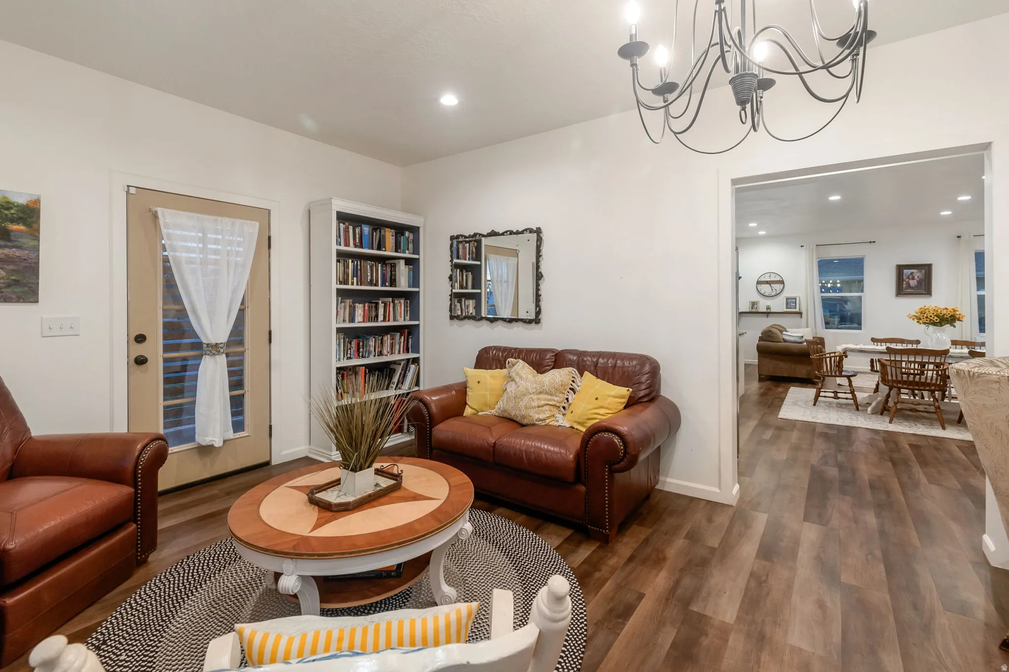 Living room featuring dark wood-type flooring, recessed lighting, and a chandelier