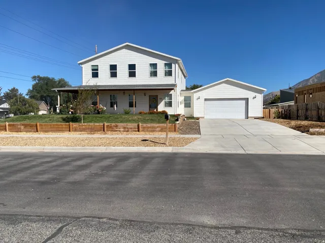 View of front of home featuring a garage, a porch, and driveway