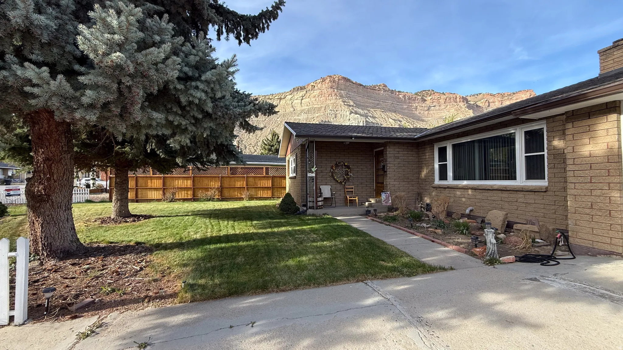 View of home's exterior featuring brick siding, a mountain view, a patio area, and a chimney