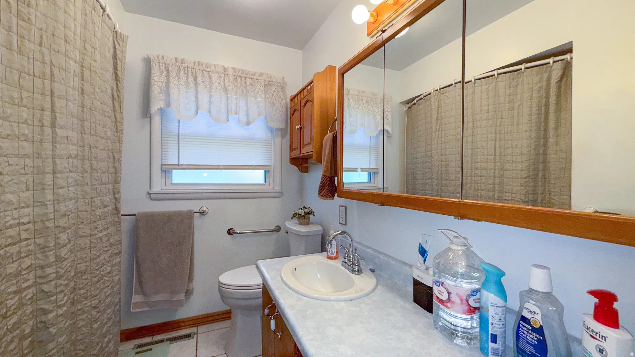 Bathroom featuring vanity, a shower with curtain, and light tile patterned flooring