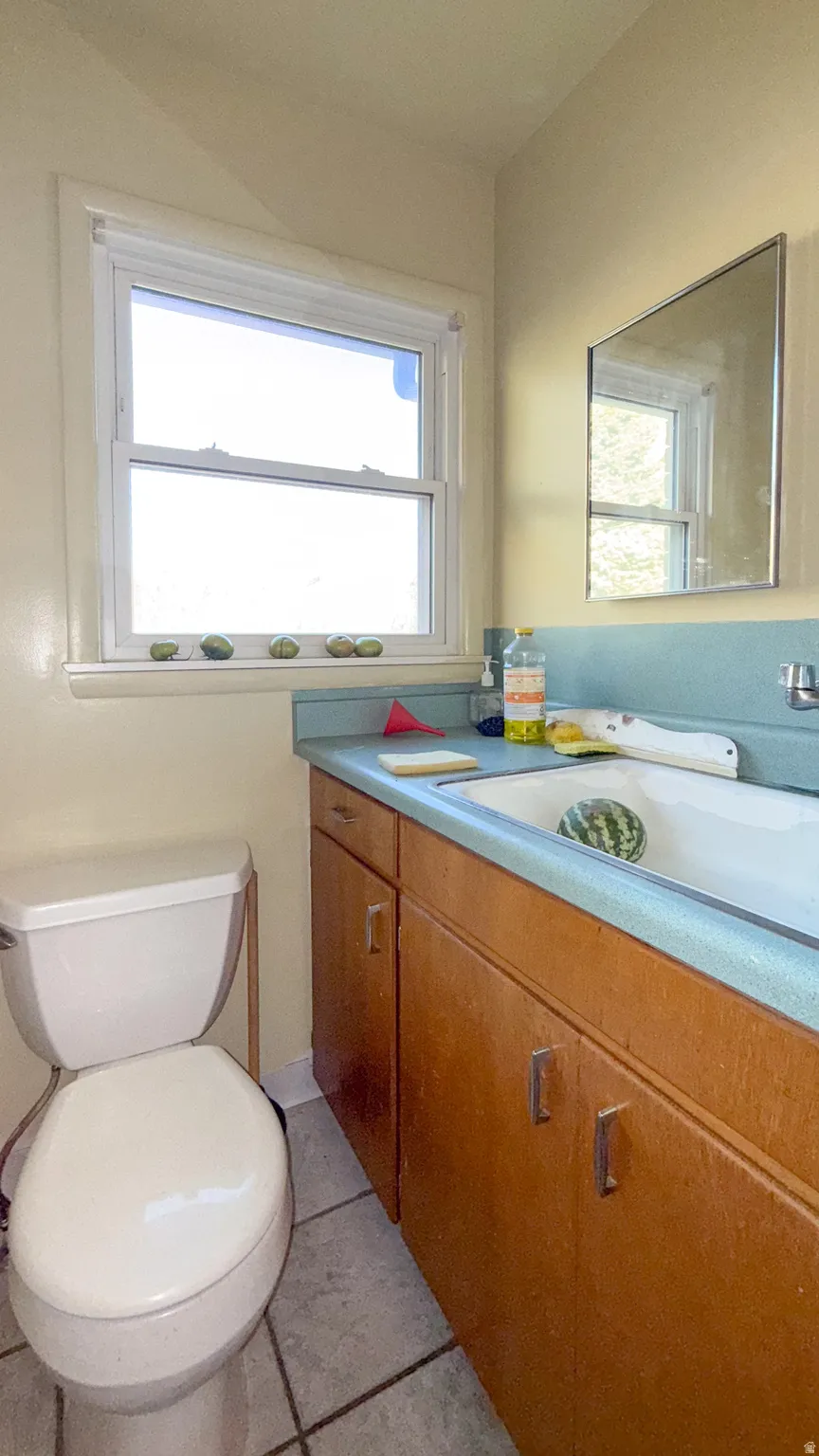 Half bathroom with light tile patterned floors and vanity