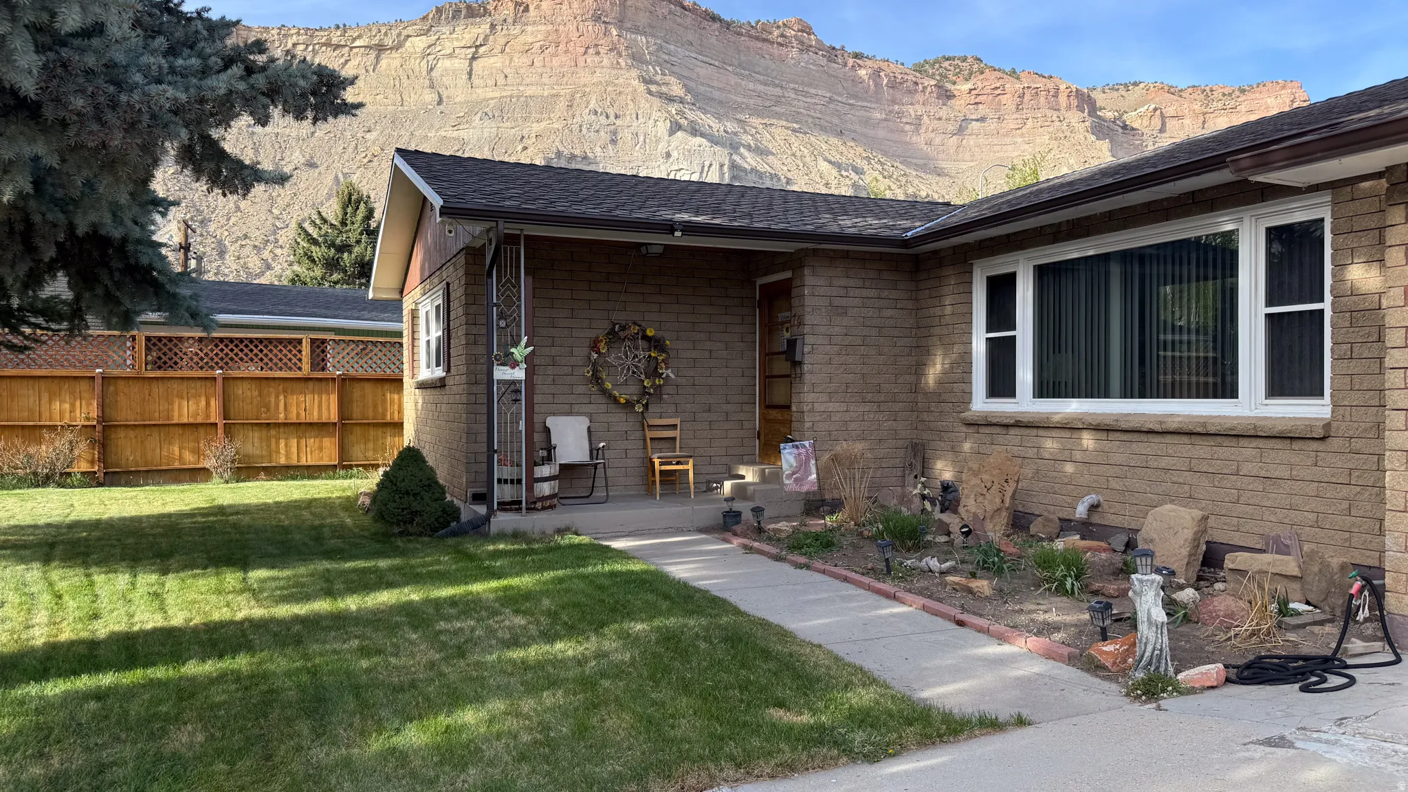 View of front of home with a mountain view, roof with shingles, and brick siding